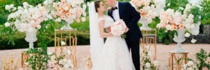 Beautiful bride and groom in the wedding ceremony area of live white and pink flowers.