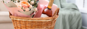 Wicker basket with gifts on table indoors